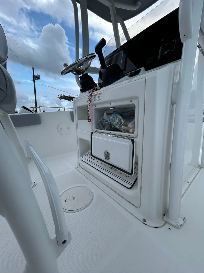 Slide: The Image of 2019 Sea Hunt 225 Ultra boat interior with storage compartment and steering wheel. - 23