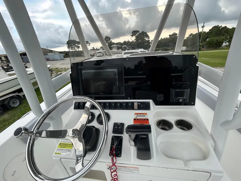 Slide: The Image of 2019 Sea Hunt 225 Ultra boat console with steering wheel and controls. - 24