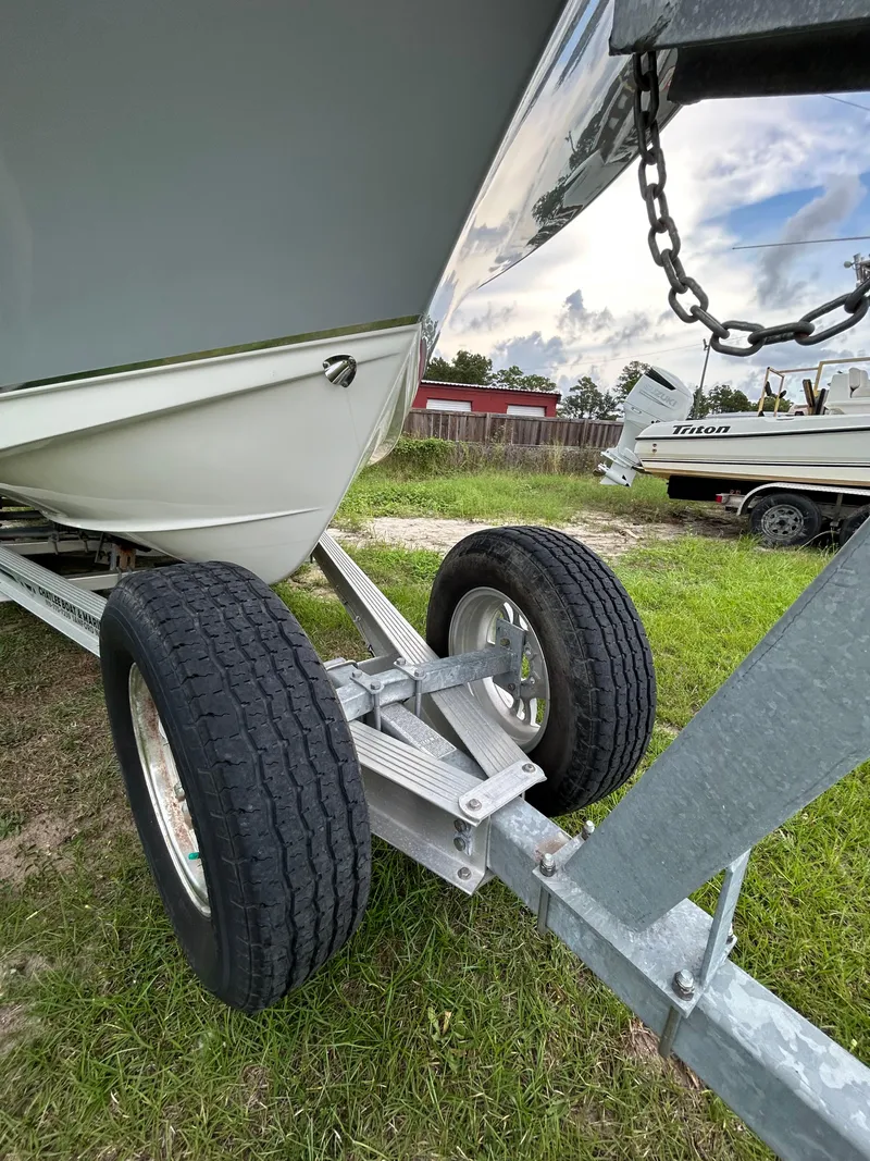 Slide: The Image of 2019 Sea Hunt 225 Ultra boat on trailer, grassy area, overcast sky. - 28