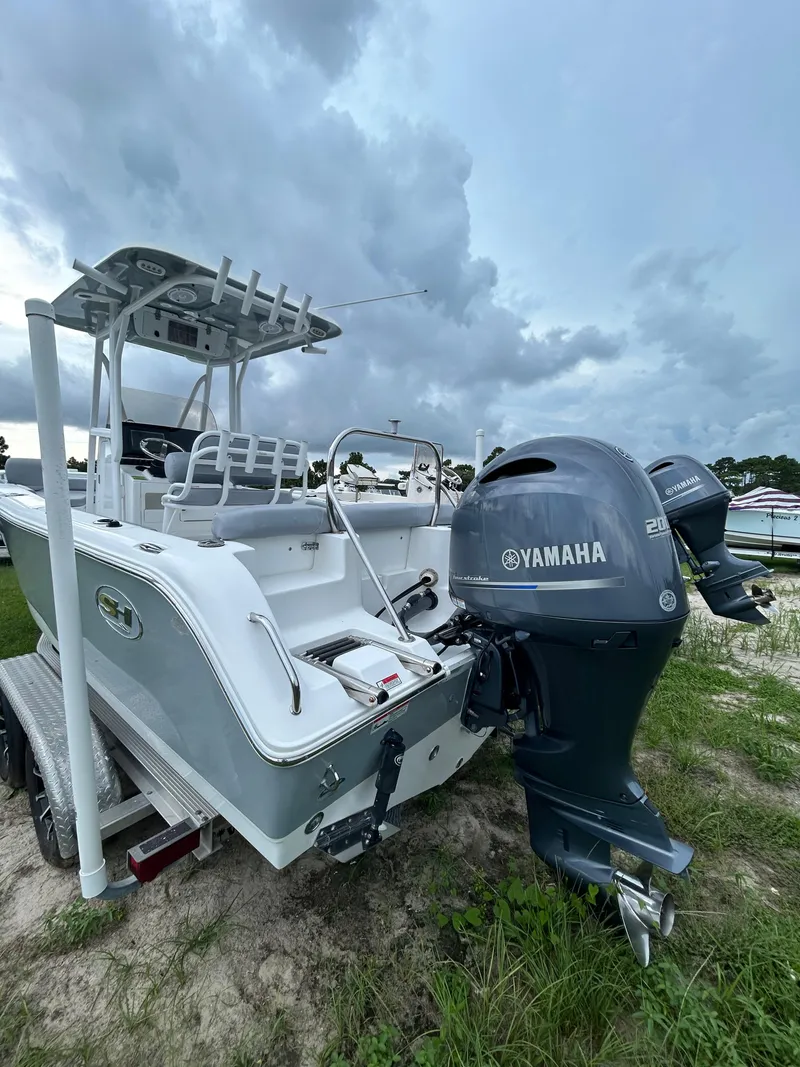 Slide: The Image of 2019 Sea Hunt 225 Ultra boat with Yamaha engine, parked on grass under cloudy sky. - 3