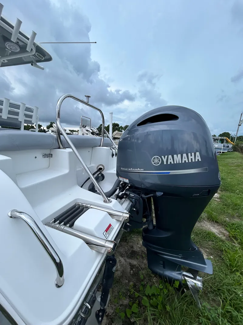 Slide: The Image of 2019 Sea Hunt 225 Ultra boat with Yamaha outboard motor, parked on grass. - 4