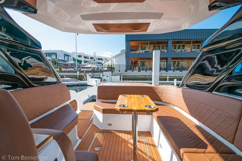 Slide: The Image of 2023 NX Boats 340 Sport Coupe interior with luxurious seating and wooden table. - 10
