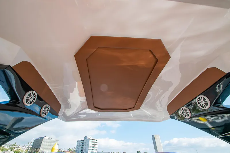 Slide: The Image of 2023 NX Boats 340 Sport Coupe ceiling with speakers, cityscape in background. - 12