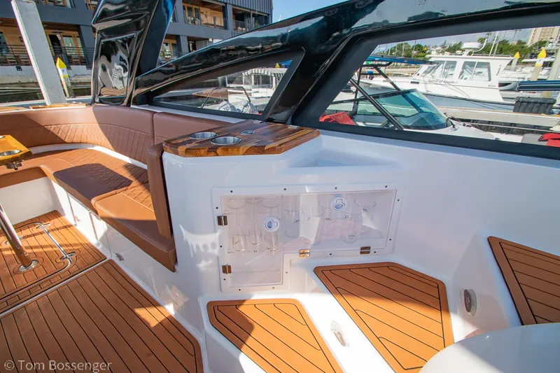 Slide: The Image of 2023 NX Boats 340 Sport Coupe interior with teak flooring and seating area. - 14