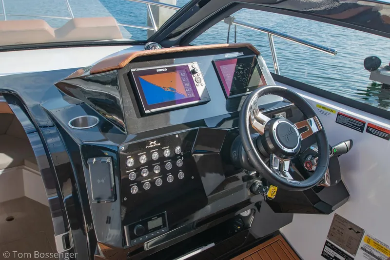 Slide: The Image of 2023 NX Boats 340 Sport Coupe dashboard with navigation screens and steering wheel. - 15