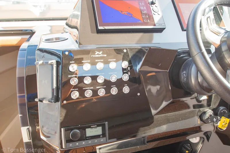 Slide: The Image of Control panel of 2023 NX Boats 340 Sport Coupe with navigation screens and steering wheel. - 18