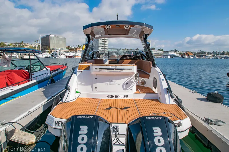 Slide: The Image of 2023 NX Boats 340 Sport Coupe docked, featuring twin Mercury 300 engines, in a marina setting. - 2