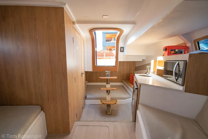 Slide: The Image of Interior of 2023 NX Boats 340 Sport Coupe, featuring modern wood finishes and compact kitchen. - 21