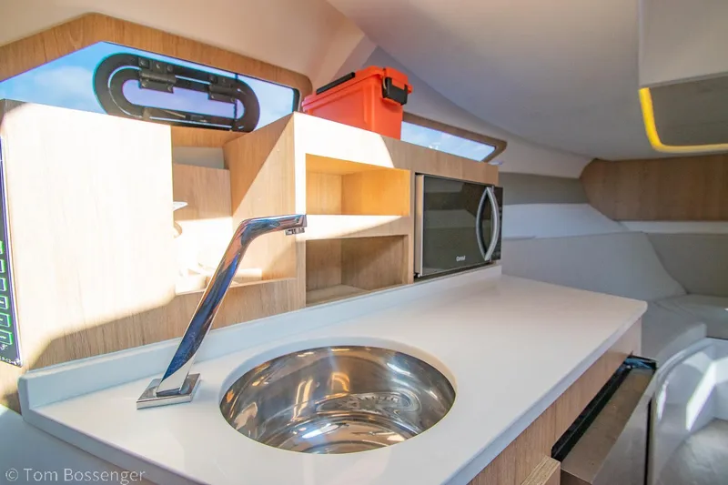 Slide: The Image of Interior of 2023 NX Boats 340 Sport Coupe with modern kitchenette and sleek design. - 23