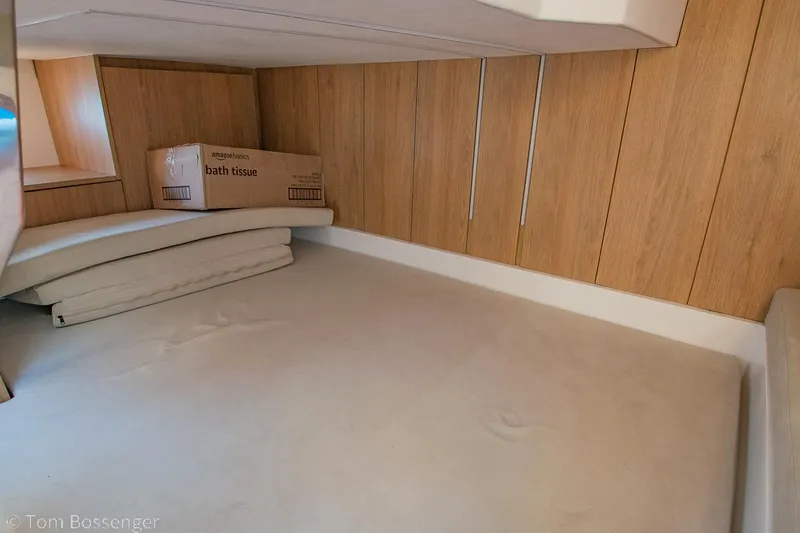 Slide: The Image of Interior cabin of 2023 NX Boats 340 Sport Coupe with wooden paneling and storage space. - 24