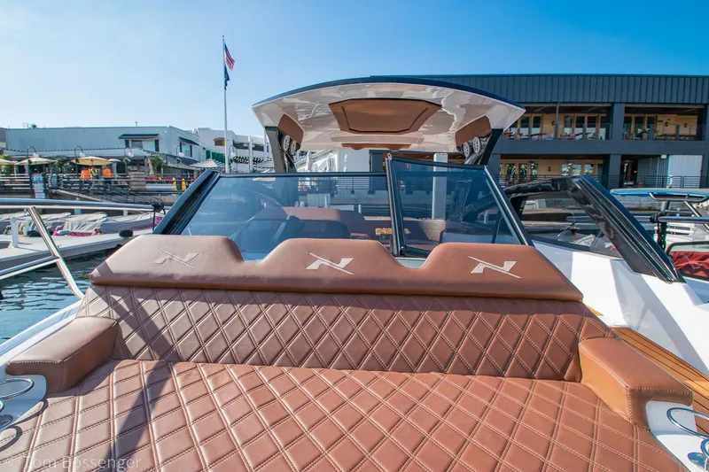 Slide: The Image of 2023 NX Boats 340 Sport Coupe with luxurious leather seating at a marina. - 28