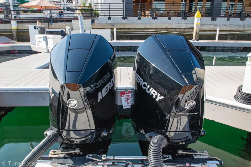 Slide: The Image of Twin Mercury outboard engines on a 2023 NX Boats 340 Sport Coupe at a marina. - 29