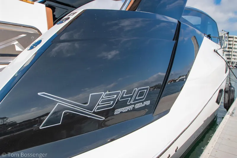 Slide: The Image of 2023 NX Boats 340 Sport Coupe docked, showcasing sleek design and branding. - 3