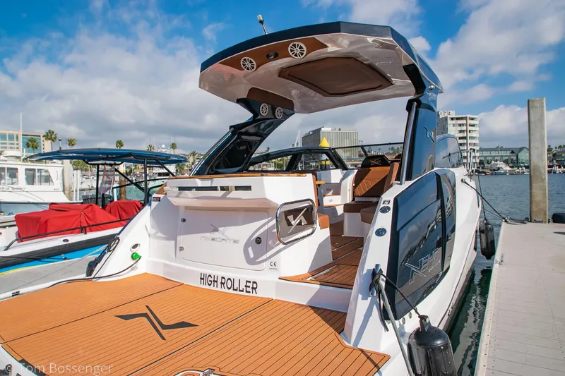 Slide: The Image of 2023 NX Boats 340 Sport Coupe docked, showcasing sleek design and luxury features. - 4