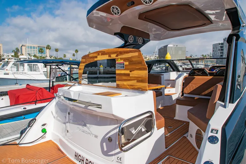 Slide: The Image of 2023 NX Boats 340 Sport Coupe, luxury yacht interior, docked in marina under blue sky. - 5