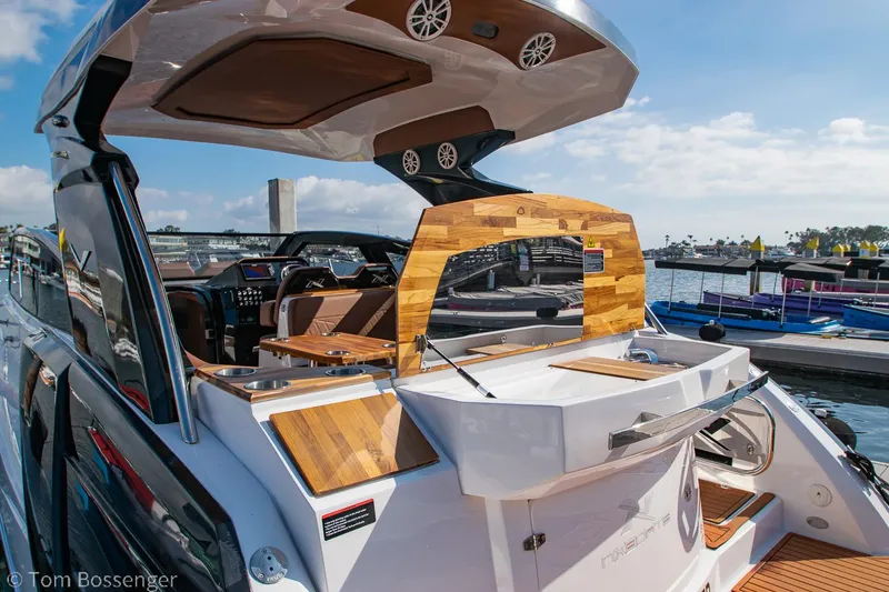 Slide: The Image of 2023 NX Boats 340 Sport Coupe, luxury yacht interior with wood accents, docked at marina. - 6
