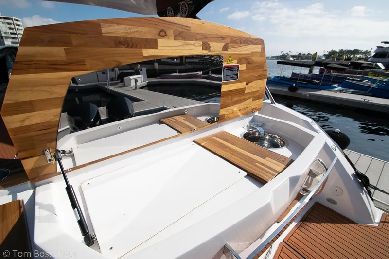 Slide: The Image of 2023 NX Boats 340 Sport Coupe with wooden deck and marina view. - 7