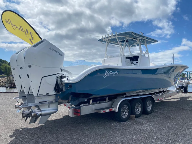 Slide: The Image of 2024 Yellowfin 36 Center Console boat on a trailer with triple Mercury outboard engines. - 2