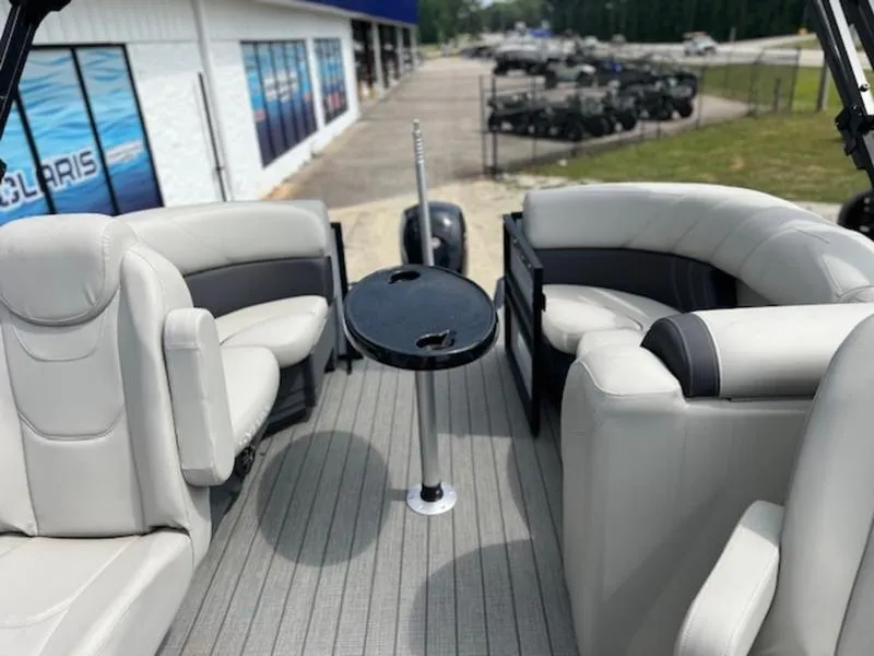 Slide: The Image of 2023 Sylvan Mirage X X1 boat interior with plush seating and a central table. - 2