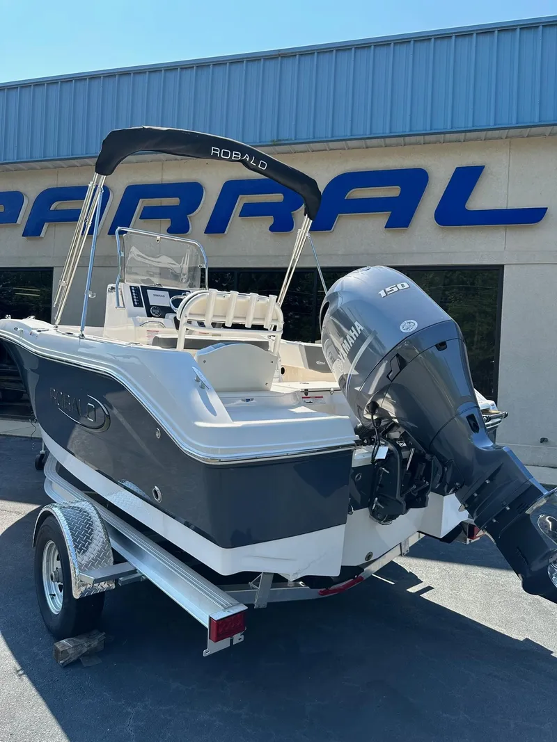 Slide: The Image of 2023 Robalo R180 Center Console boat on trailer outside dealership. - 9