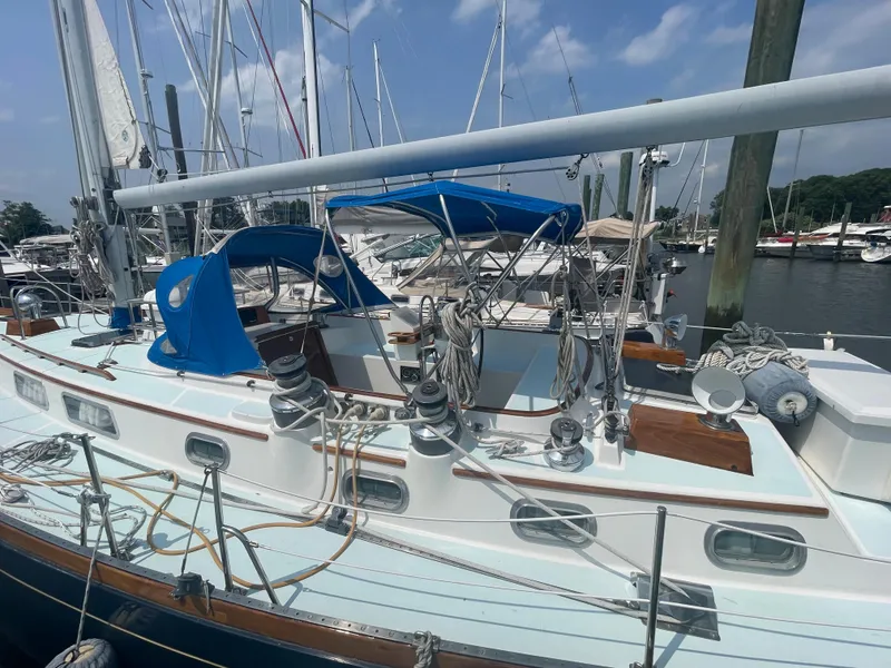 Slide: The Image of 1983 Bristol 45.5 Center Cockpit sailboat docked at marina, blue canopy, and rigging visible. - 11