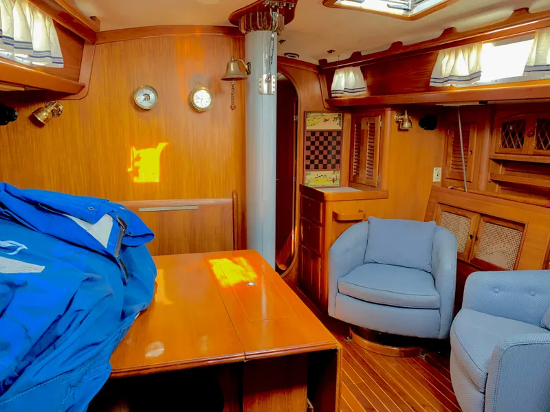 Slide: The Image of Interior of 1983 Bristol 45.5 Center Cockpit sailboat with wooden furnishings and blue seating. - 17