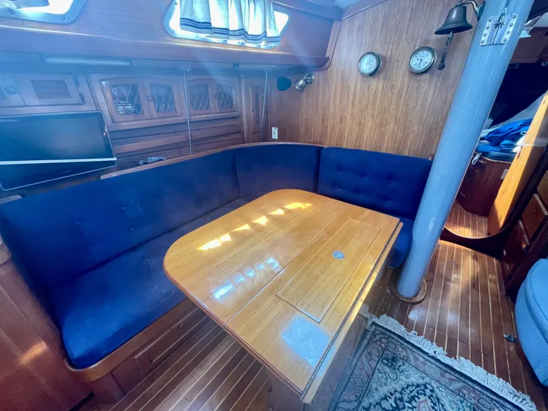 Slide: The Image of 1983 Bristol 45.5 Center Cockpit interior with blue seating and wooden table. - 20