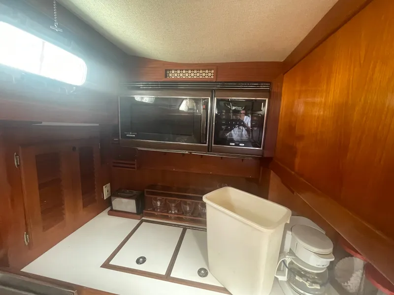 Slide: The Image of 1983 Bristol 45.5 Center Cockpit galley with microwave, storage, and coffee maker. - 26