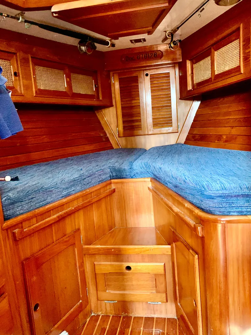 Slide: The Image of 1983 Bristol 45.5 Center Cockpit interior with wooden cabinetry and blue bedding. - 35