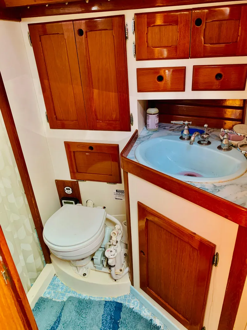 Slide: The Image of 1983 Bristol 45.5 Center Cockpit bathroom with wooden cabinets and a marine toilet. - 39