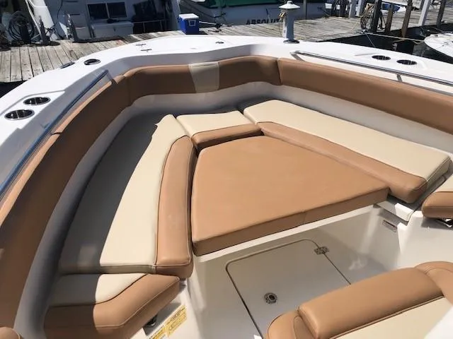 Slide: The Image of 2023 NauticStar 24 XS boat with tan and cream cushioned seating area. - 11
