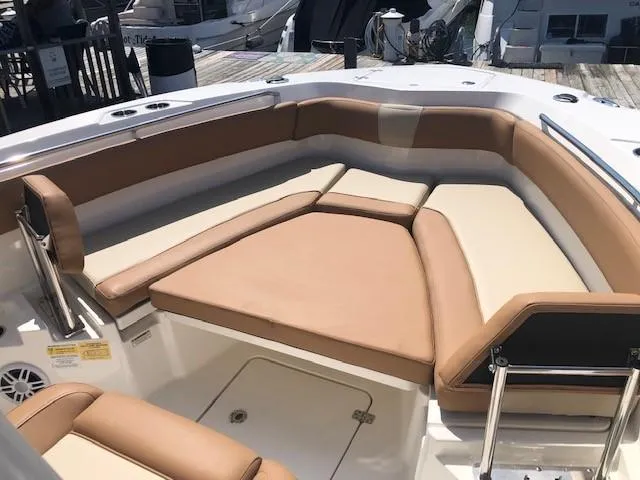 Slide: The Image of 2023 NauticStar 24 XS boat with tan and white cushioned seating. - 12