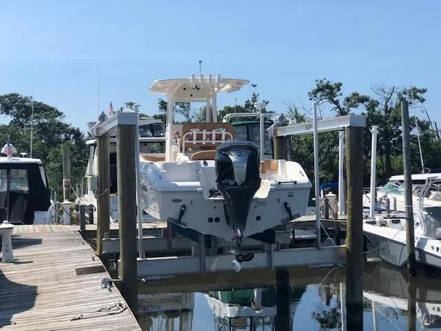 Slide: The Image of 2023 NauticStar 24 XS boat docked at a marina. - 2