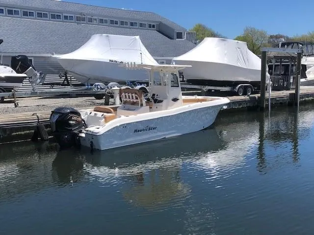 Slide: The Image of 2023 NauticStar 24 XS boat docked at a marina. - 3