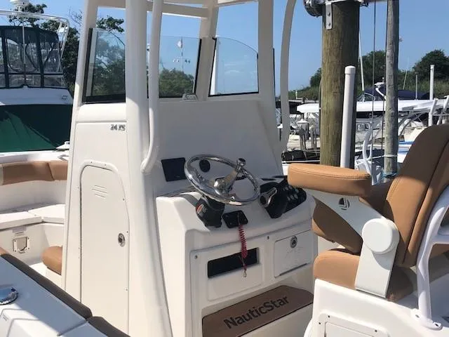 Slide: The Image of 2023 NauticStar 24 XS boat console and seating at marina. - 4
