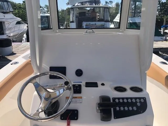 Slide: The Image of 2023 NauticStar 24 XS boat console with steering wheel and controls. - 5