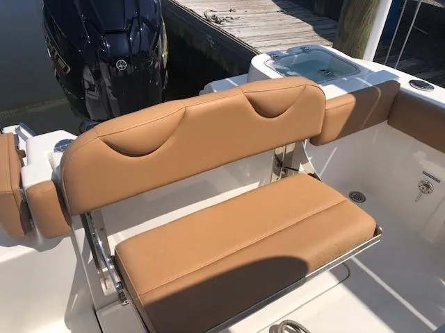 Slide: The Image of 2023 NauticStar 24 XS boat with tan seating and Yamaha outboard motor. - 9