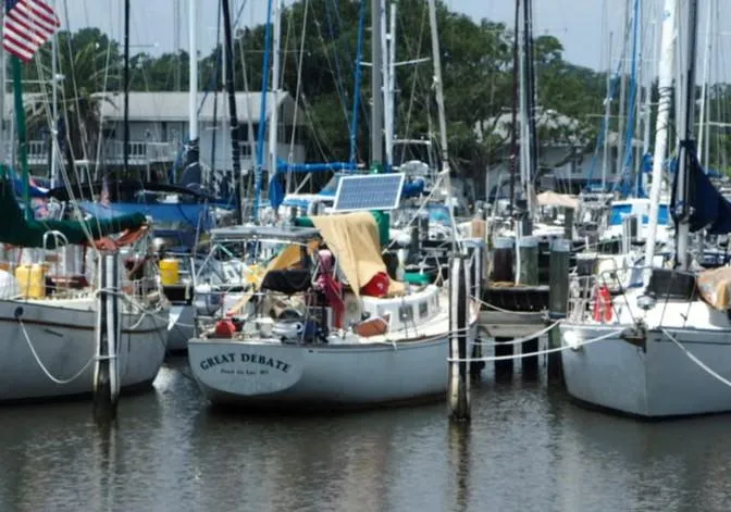 Slide: The Image of 1971 Tartan 34C sailboat named "Great Debate" docked in a busy marina. - 3