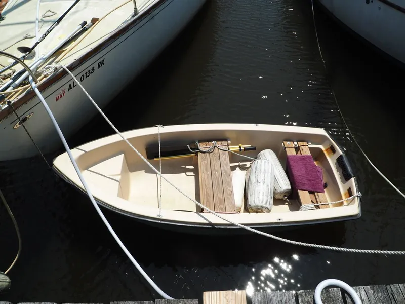 Slide: The Image of Small boat docked between larger vessels, featuring wooden seats and nautical equipment. - 4