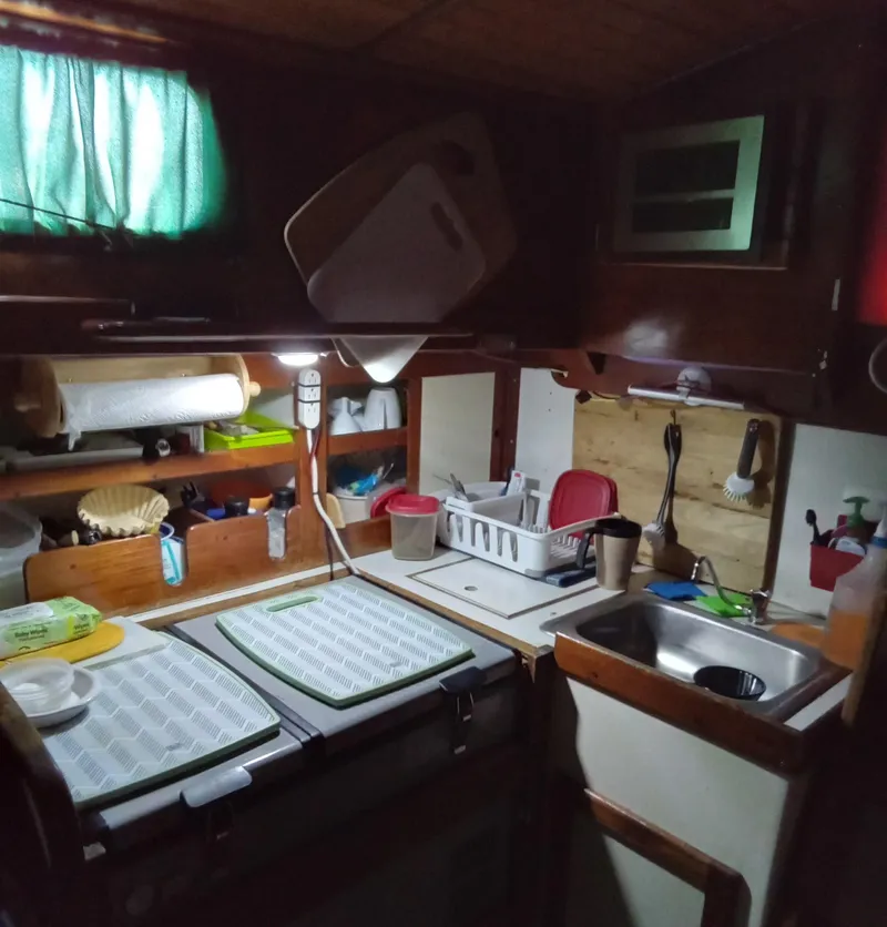 Slide: The Image of 1971 Tartan 34C sailboat kitchen with wooden cabinets and compact sink area. - 5