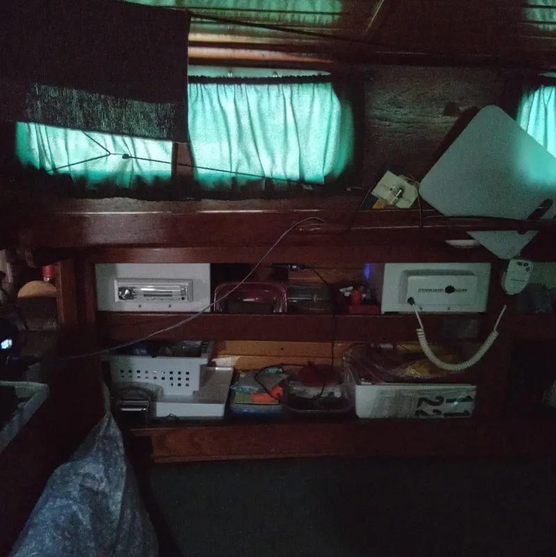 Slide: The Image of Interior of a 1971 Tartan 34C sailboat with wooden shelves and green curtains. - 6