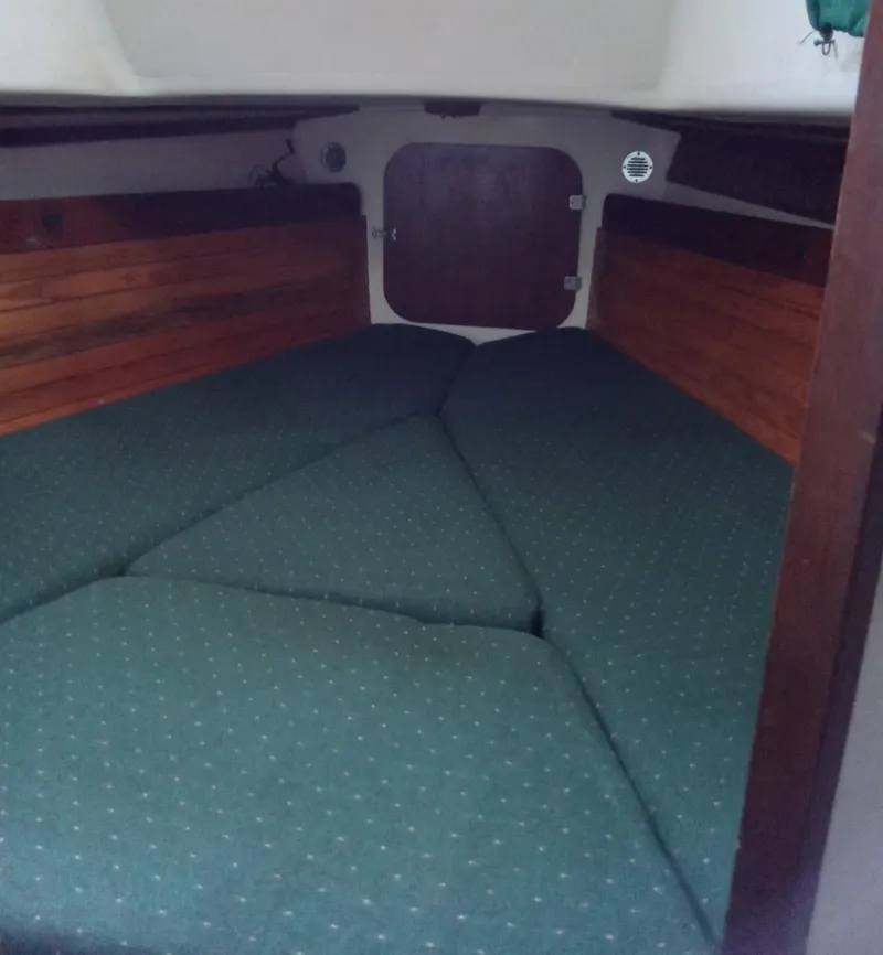 Slide: The Image of Interior cabin of a 1971 Tartan 34C sailboat with green cushioned bedding. - 8