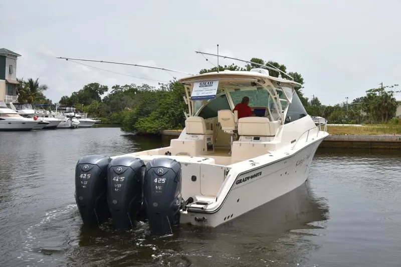 Slide: The Image of 2019 Grady-White Express boat with triple 425 HP engines on a calm waterway. - 2