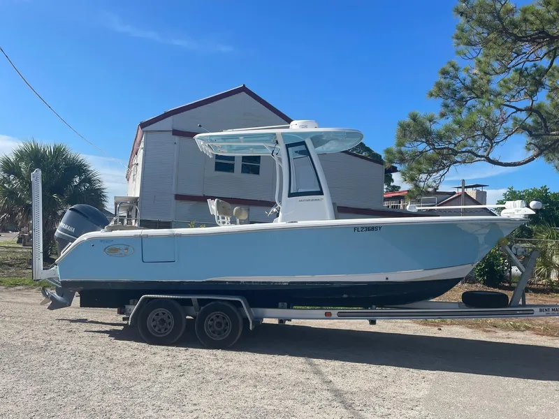 Slide: The Image of 2018 Sea Hunt Ultra 235 SE boat on a trailer in a residential area. - 1