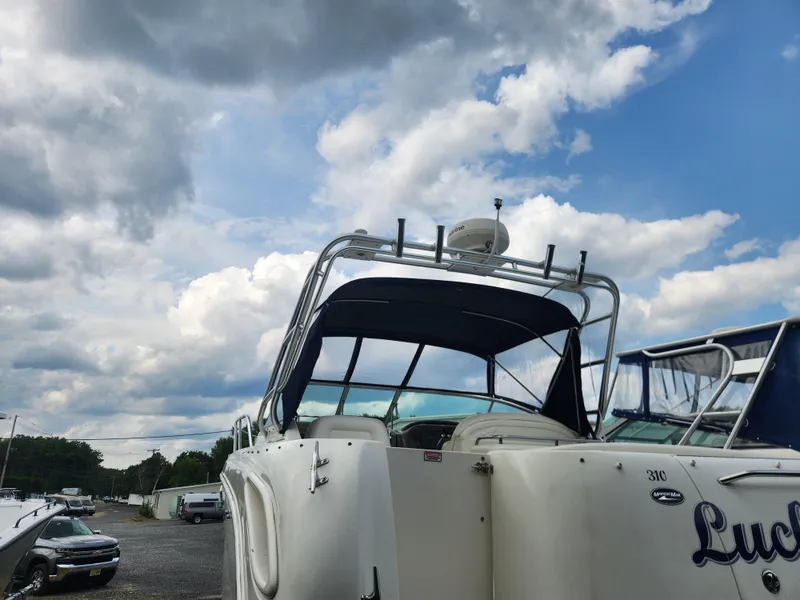 The Image of 2004 Sea Ray 290 Amberjack boat docked under a cloudy sky. - 1