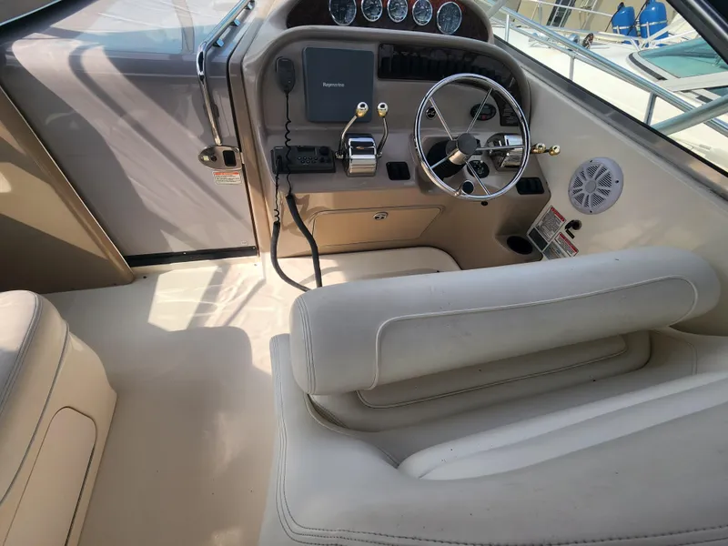 Slide: The Image of 2004 Sea Ray 290 Amberjack boat cockpit with steering wheel and control panel. - 21