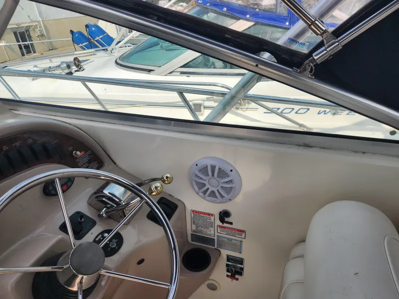 Slide: The Image of 2004 Sea Ray 290 Amberjack helm with steering wheel and control panel. - 27