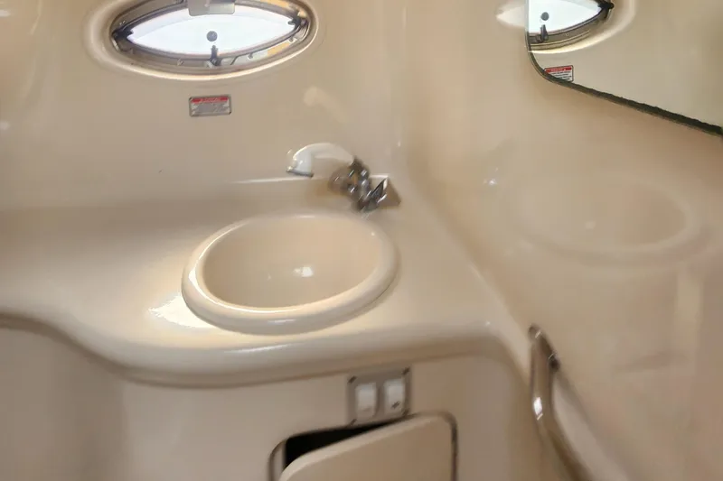 Slide: The Image of 2004 Sea Ray 290 Amberjack bathroom sink with mirror and porthole window. - 37