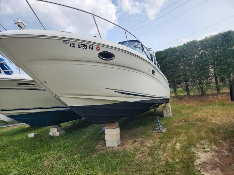 Slide: The Image of 2004 Sea Ray 290 Amberjack boat on stands, side view, outdoors. - 8