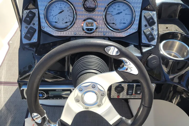 Slide: The Image of 2014 Larson LSR 2100 I/O boat dashboard with steering wheel and gauges. - 6